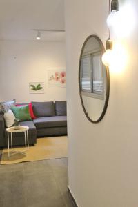 uma sala de estar com um espelho e um sofá em 2R full of charm and style at heart of Florentine em Tel Aviv