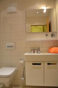 ein Badezimmer mit einem Waschbecken, einem WC und einem Spiegel in der Unterkunft Ferienwohnung Familie Böckmann auf Norderney in Norderney