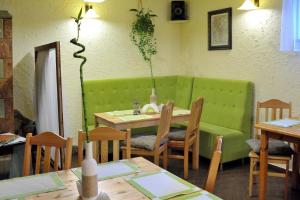 a dining room with a table and a green couch at Villa Dom Julii in Sanok