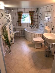 łazienka z wanną, toaletą i umywalką w obiekcie Grundhof Wolfskrug w mieście Wolfskrug
