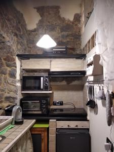 uma cozinha com um fogão e um micro-ondas em l'arco di Sersa em Riccò del Golfo di Spezia