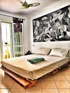 a bed in a bedroom with a large painting on the wall at Sal Service - Beach residence in Santa Maria