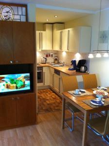 eine Küche mit einem Tisch und eine Küche mit einem TV in der Unterkunft Ferienwohnung Familie Böckmann auf Norderney in Norderney