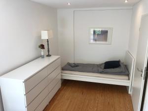 une chambre avec un lit et un mur blanc dans l'établissement 23 Fielweg, à Wewelsfleth 12 autres photos