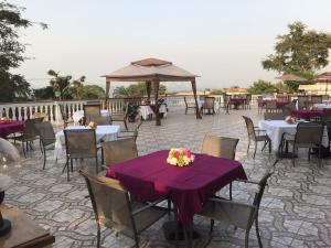a patio with tables and chairs with purple table cloth at Hotel Cabenda in Freetown
