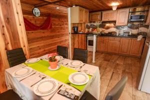 a dining room with a table and a kitchen at Le Chalet à Joel in Cilaos