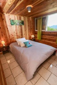 una camera da letto con un grande letto in una camera in legno di Le Chalet à Joel a Cilaos