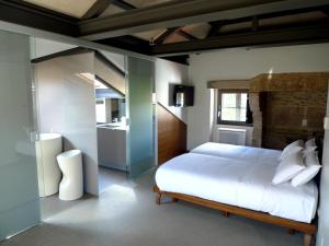 a bedroom with a white bed and a sink at Blanco Apartamentos Turísticos in Santiago de Compostela