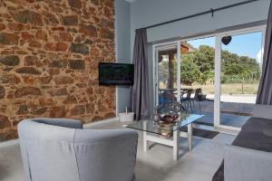 ein Wohnzimmer mit einem Tisch und einer Steinmauer in der Unterkunft Quinta da Villa in Cascais