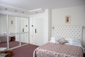 a bedroom with a large bed with a pink blanket at Amethyst House in Otopeni