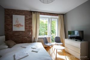 ワルシャワにあるSaska Kępa Apartamentyのベッドルーム1室(ベッド1台、椅子2脚、窓付)