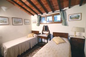 a bedroom with two beds and a table with a mirror at Monteriggioni Castello in Monteriggioni