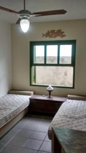 een slaapkamer met 2 bedden en een raam bij Casa em Toque Toque Pequeno in Pauba