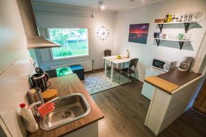 una pequeña cocina con fregadero y mesa en Foxtail Apartment, en Rovaniemi