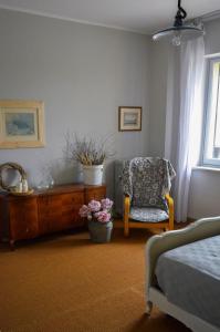 a bedroom with a bed and a dresser and a chair at Tenuta Ajrale in Vigone