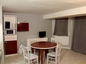 a dining room with a table and white chairs at 7 Rue du Docteur Paul Jouve in Digne-les-Bains