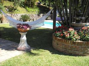 a hammock in a vase next to some flowers at Suites em meio a Mata Atlântica in Itaipava