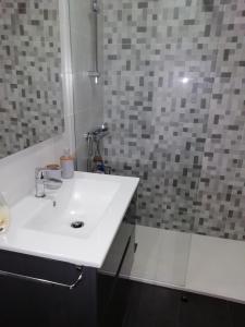 y baño con lavabo blanco y ducha. en Calle Maceiras, 1 - 1B, en Combarro