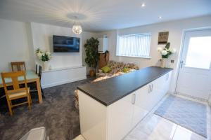 a kitchen and living room with a table and a couch at Fantastic Large House with Private Parking in Bradford