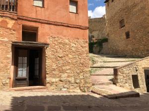 een stenen gebouw met een trap naar een deur bij Casa De La Roca in Albarracín