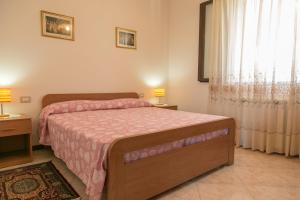1 dormitorio con 1 cama, 2 lámparas y ventana en Bed And Breakfast Eden Green, en Alghero