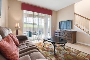 - un salon avec un canapé, une télévision et une table dans l'établissement Villa Orlando Joy, à Davenport