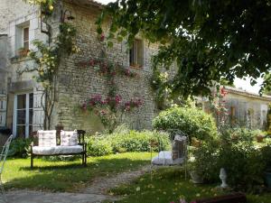 a garden with two chairs in front of a building at A L'Antan - La Ferme D'Octave in Saint-Hilaire-de-Villefranche