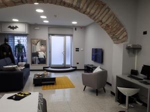 uma sala de estar com um sofá e cadeiras e uma televisão em Batcave em Pula