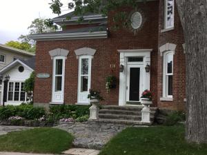 een rood bakstenen huis met witte ramen en een deur bij Stone Garden Inn in Trenton