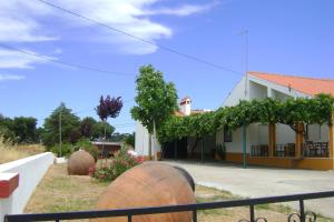 una casa con dos grandes barriles de vino delante en Tapada da Beirã, en Marvão