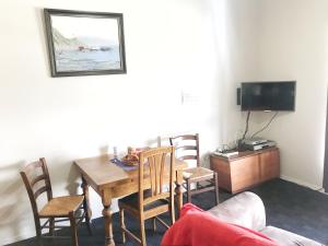 a dining room with a table and chairs and a tv at The Pier Hotel in Kaikoura
