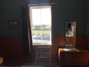 
a room with a chair and a window at The Pier Hotel in Kaikoura

