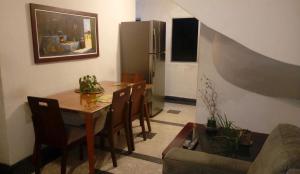 uma cozinha com uma mesa e cadeiras e um frigorífico em Minha Casa, Seu Hostel no Recife