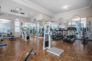 a gym with several treadmills and machines in a room at Broadbeach in Gold Coast