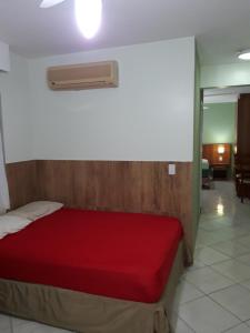 ein Schlafzimmer mit einem Bett mit einer roten Tagesdecke in der Unterkunft 1307 AP 2 Quartos Shopping , banheira de hidro privativa , bebidas liberadas nas piscinas , e com internet no ap, proximo ao shopping singapura in Caldas Novas + 58 Fotos