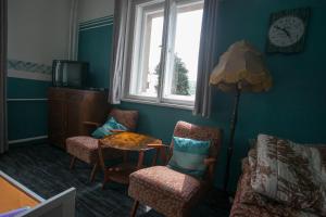 a living room with a table and chairs and a clock at Vila Sazava in Sázava