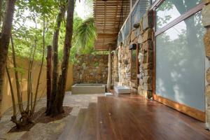 a room with a stone wall and a tree at Kottawatta Village in Udawalawe