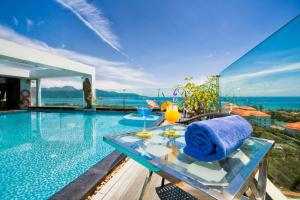 Una piscina con una mesa con una toalla azul. en Sea Phoenix Hotel Da Nang, en Da Nang