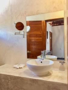 a white sink sitting under a mirror in a bathroom at Hotel Sun Ha Bacalar in Bacalar