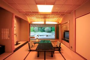 a dining room with a table and a television at Akazawa Geihinkan in Ito