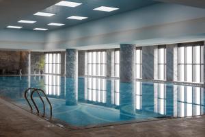 a large swimming pool with windows in a building at Pullman Shanghai South in Shanghai