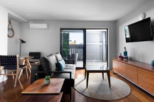 un soggiorno con divano e TV di Veriu Randwick a Sydney