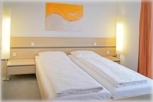 A bed or beds in a room at Gasthof-Pension Schütz
