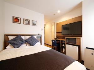 Habitación de hotel con cama y TV de pantalla plana. en HOTEL MYSTAYS Sapporo Susukino en Sapporo