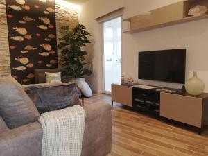 a living room with a couch and a flat screen tv at Three Cities Apartments in Cospicua