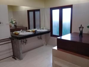 un bagno con due lavandini e una grande finestra di Baan Ton Rak Boutique Resort a Ko Chang