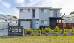 a white house with a fence and a yard at Wallsend on Longworth in Newcastle