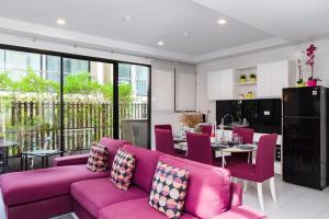 a living room with a purple couch and a kitchen at Pause on Samui Residences in Bophut