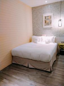 a bedroom with a large bed with white sheets at King Wow Inn in Tainan