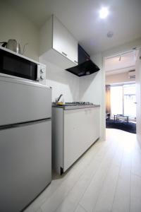 a kitchen with white appliances and a white floor at Sorapia Tokyo in Tokyo